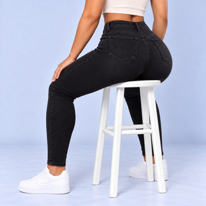 Sculpt Skinny BBL jean in black, seated on a stool