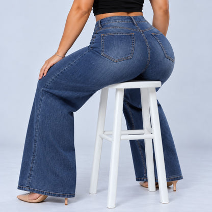 Sculpt Wide Leg BBL jean in dark blue, seated on a stool