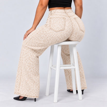 Sculpt Wide Leg BBL jean in white leopard, seated on a stool